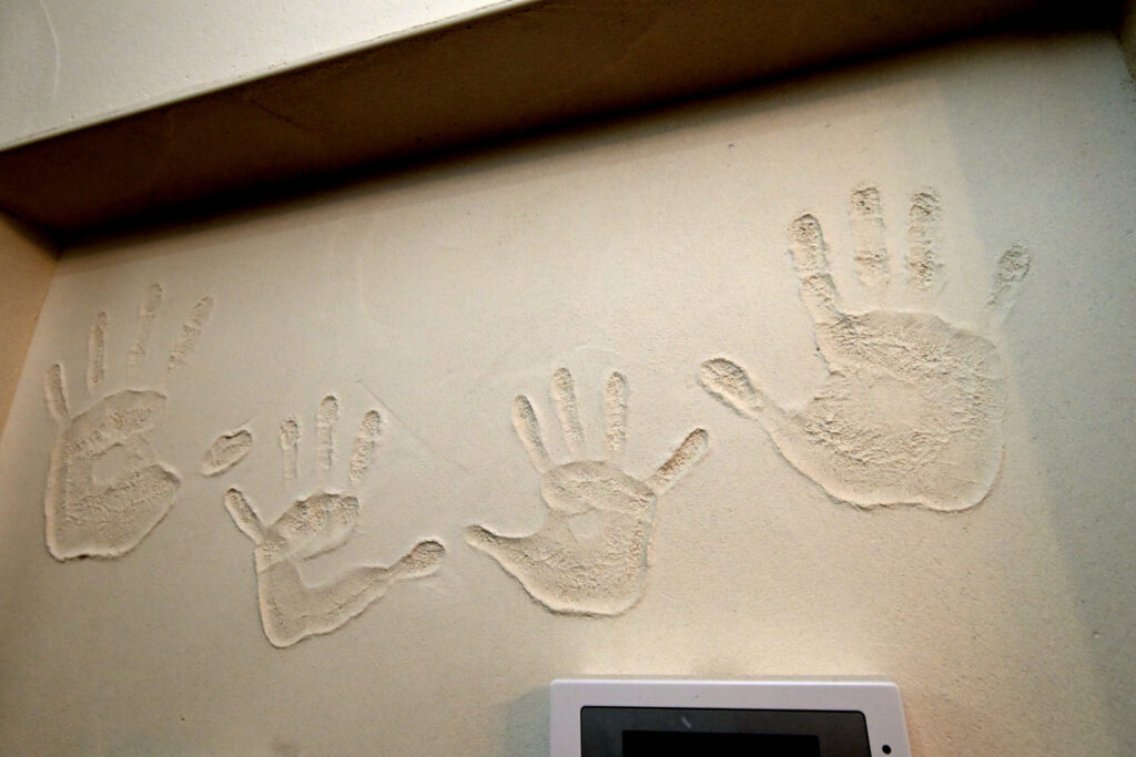 漆喰の壁に押された家族の手形